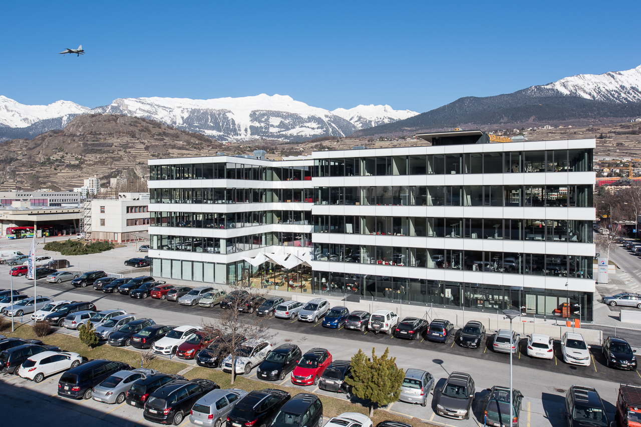 Vue extérieure du bâtiment 1950 Business Center avec parking et montagnes